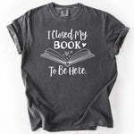 Grey, short-sleeve t-shirt with I Closed My Book To Be Here graphic.