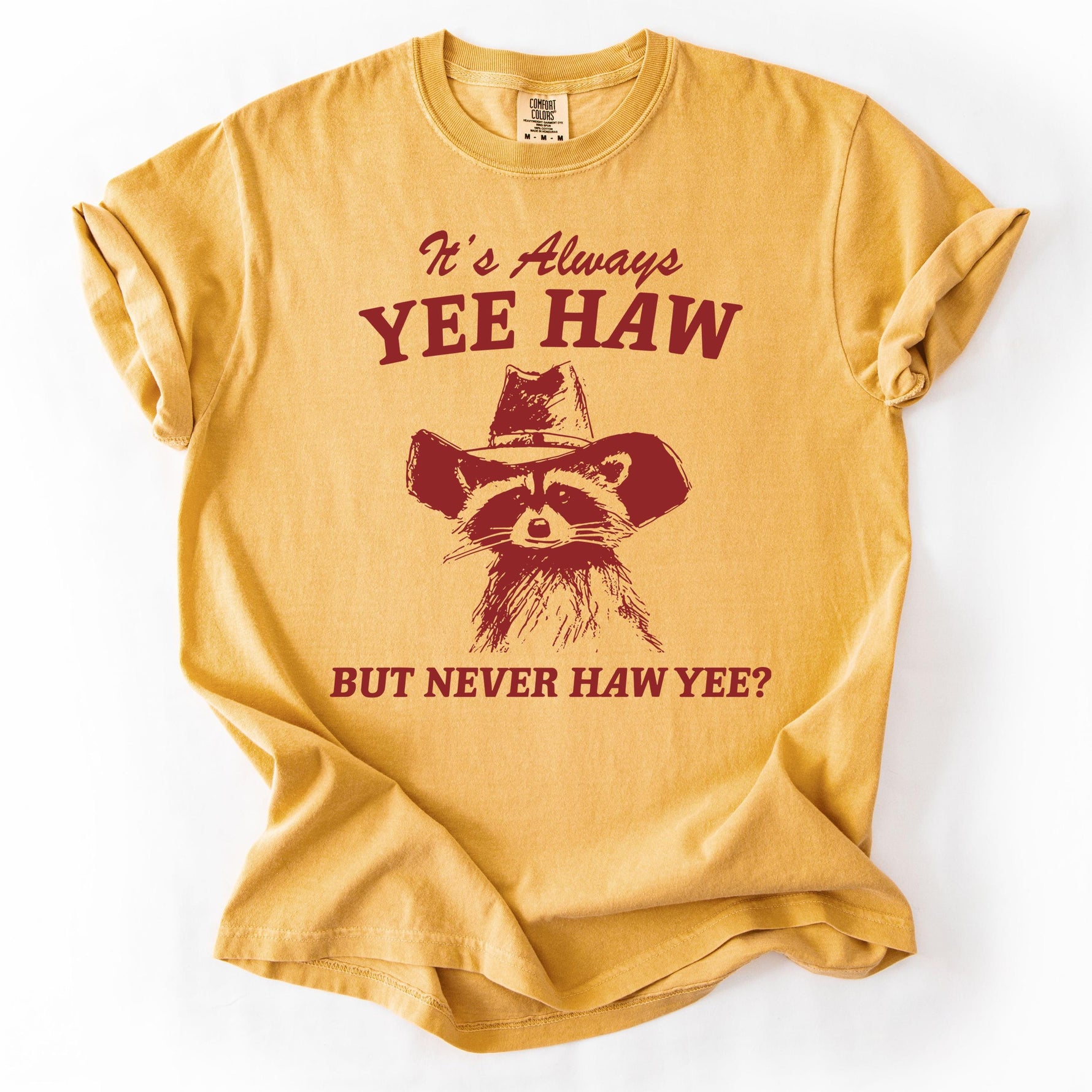 Yellow graphic t-shirt with raccoon design and text.