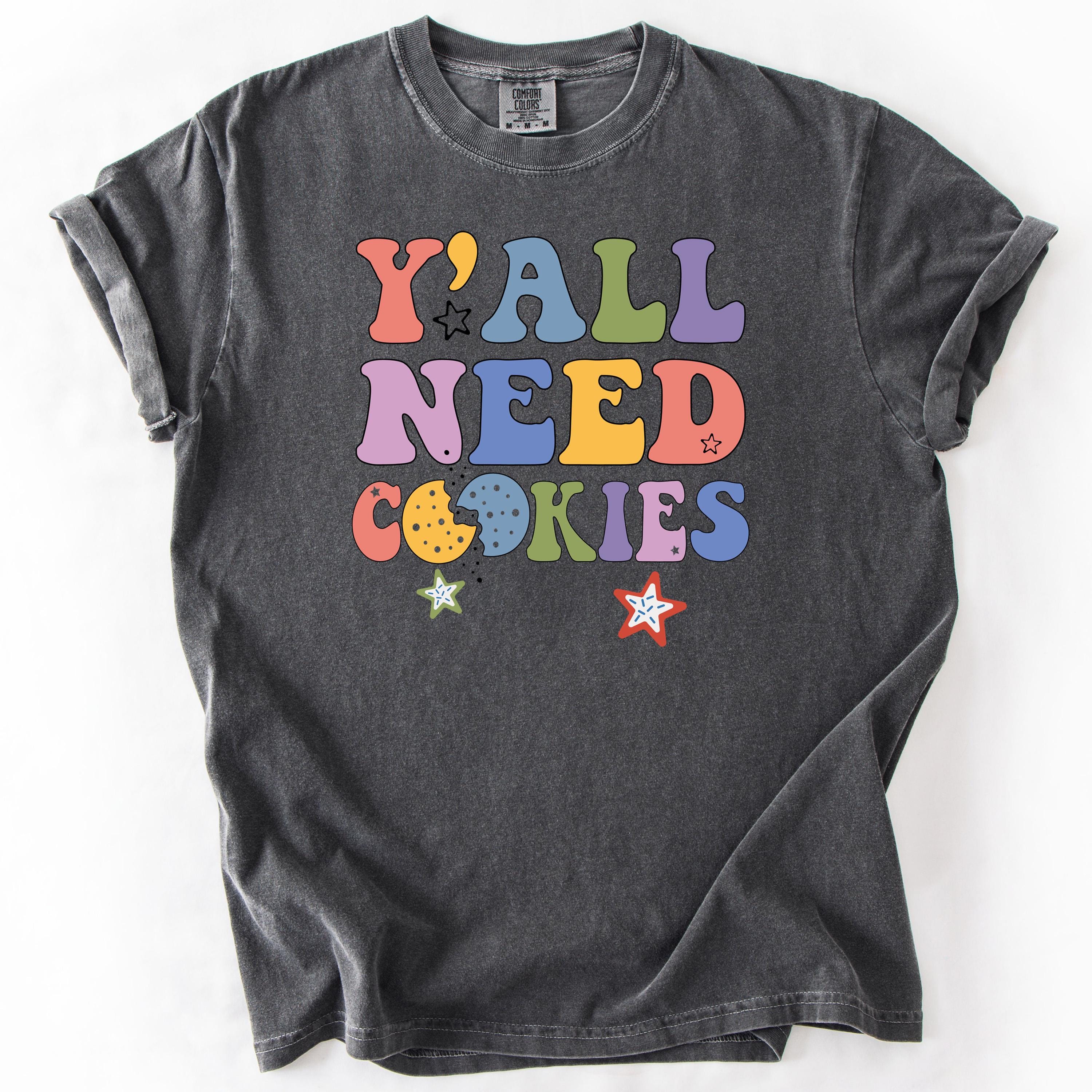 Gray graphic t-shirt with Y'All Need Cookies text in colorful letters.