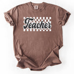 Brown t-shirt with Teacher graphic and checkerboard pattern.