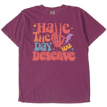 Purple graphic t-shirt with Have the Day You Deserve design.